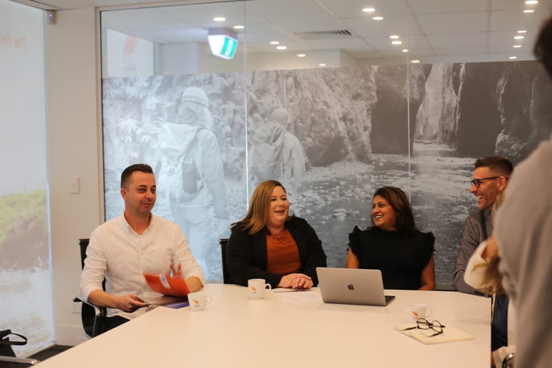 The AGS Financial Group accounting team meeting around a table in the office